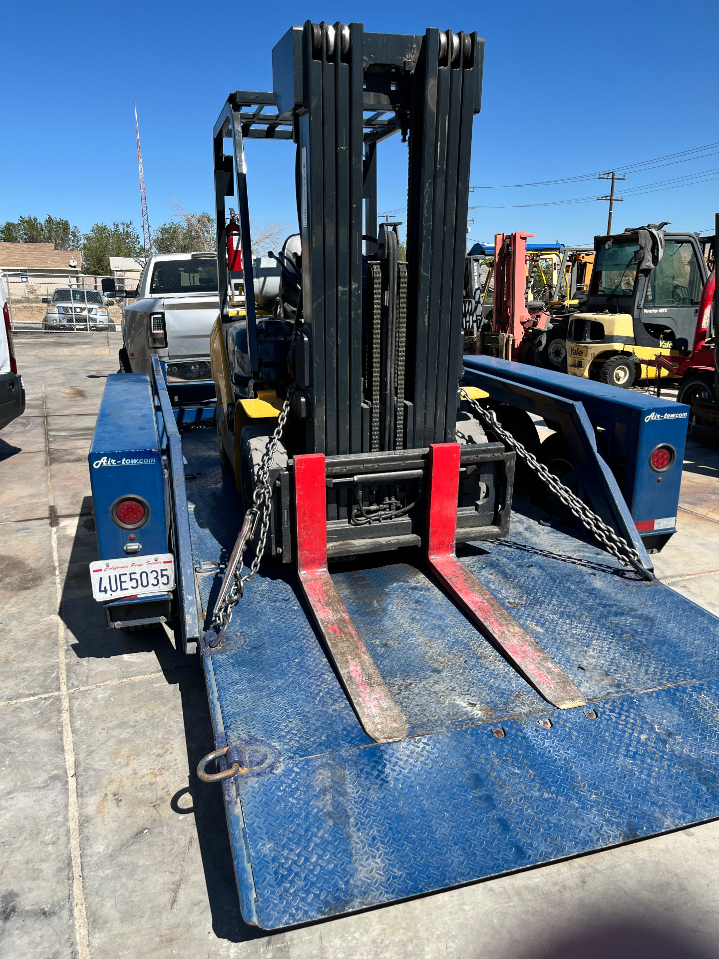 Forklift secured on a flatbed trailer for pick-up and delivery service